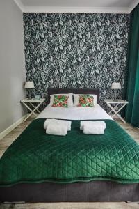 ein Schlafzimmer mit einem großen grünen Bett mit zwei Kissen in der Unterkunft Zielony Apartament DE LUX dla 4 osób Chorzów Katowice in Chorzów