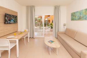 uma sala de estar com um sofá e uma mesa em HSM Club Torre Blanca em Sa Coma