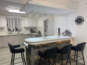 a kitchen with a bar with chairs around it at Villa santa avec piscine et jardin in Pointe aux Piments