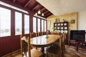 uma sala de jantar com mesa, cadeiras e janelas em Bonito y acogedor apartamento con terraza em Los Realejos