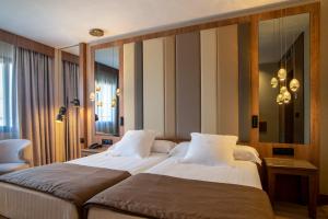 a hotel room with two beds and a mirror at Hotel Granada Center in Granada
