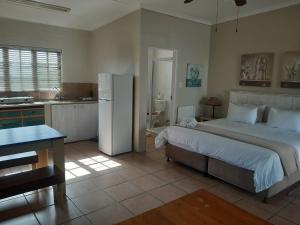 a bedroom with a large bed and a kitchen at Tourist Lodge Gansbaai in Gansbaai