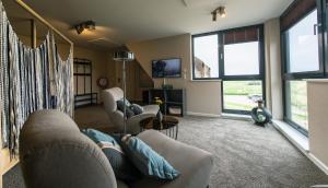 a living room with a person laying on a couch at Gräfinhof in Nordstrand