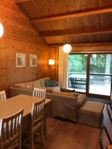 Chalet op rustig vakantiepark في Heure: غرفة معيشة مع أريكة وطاولة