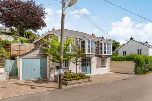 a white house with a blue garage on a street at Armando in Truro