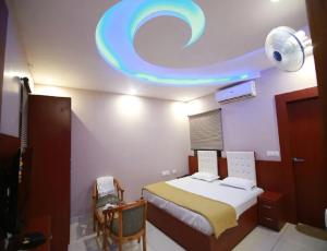 a bedroom with a bed and a ceiling with a circular light at Hotel Kings, Rohtak in Rohtak