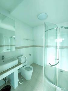 uma casa de banho branca com um chuveiro e um WC. em แทมมารินด์ em Ban Khlong Tha Thong Lang