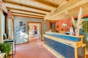 a bar in a restaurant with a wooden ceiling at Hotel Le Bois Joli in Bernex