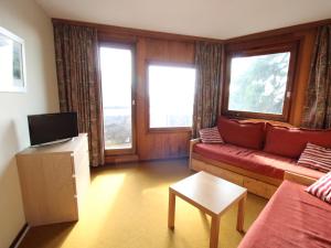 a living room with a couch and two windows at Appartement Avoriaz, 2 pièces, 5 personnes - FR-1-633-23 in Avoriaz