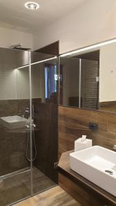 La salle de bains est pourvue d'un lavabo et d'une douche en verre. dans l'établissement Ca Bianca, à Montiano
