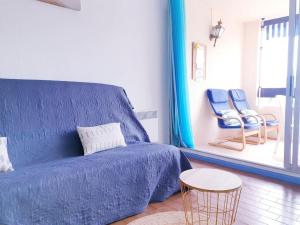 ein Wohnzimmer mit einem blauen Sofa und zwei blauen Stühlen in der Unterkunft Agréable Studio Cabine - piscine - parking - proche Plage RICHELIEU in Cap d'Agde