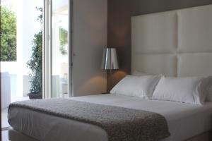 - une chambre avec un grand lit blanc et une fenêtre dans l'établissement Soglow Business Class Hotel, à Molfetta