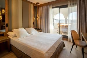 a bedroom with a large bed and a balcony at Hotel Granada Center in Granada