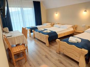 Pokój z 4 łóżkami, stołem i krzesłami w obiekcie Willa u Polczyków w mieście Białka Tatrzanska