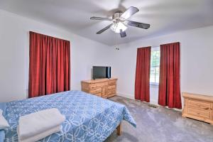 um quarto com uma cama e uma ventoinha de tecto em Convenient Jacksonville Home with Yard and Patio! em Jacksonville