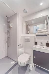 La salle de bains est pourvue de toilettes, d'un lavabo et d'une douche. dans l'établissement Student Factory Le Havre Les Docks, au Havre