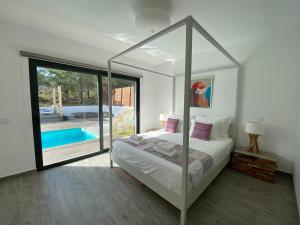 een slaapkamer met een hemelbed en een zwembad bij Cairnvillas - Villa Solar C37 Luxury Villa with Swimming Pool near Beach in Aljezur