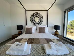 una camera da letto con un letto grande con due cuscini sopra di Cairnvillas - Villa Solar C37 Luxury Villa with Swimming Pool near Beach ad Aljezur
