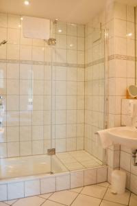 ein Bad mit einer Dusche und einem Waschbecken in der Unterkunft Hotel Weinhaus Hoff in Bad Honnef am Rhein