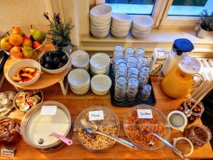 a wooden table with bowls and plates of food on it at Adventure Hostel Interlaken in Interlaken