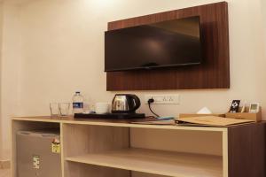 a room with a desk with a tv on the wall at Sandbanks Beach Resort in Arambol