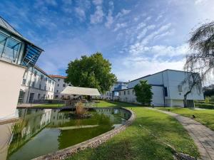 une cour avec un étang en face d'un bâtiment dans l'établissement Spectrum Kirche Exerzitien-und Bildungshaus auf Mariahilf, à Passau