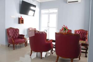 雅加達的住宿－Brahma Hotel Mitra RedDoorz，一间带椅子和桌子的房间以及一台电视