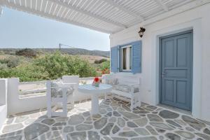 a patio with a table and chairs and a blue door at Palm Heaven Boutique Apartments in Antiparos
