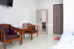 雅加達的住宿－Brahma Hotel Mitra RedDoorz，一间带桌椅和一张床的用餐室