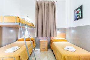 1 dormitorio con 2 literas y ventana en Albergue Inturjoven Malaga, en Málaga