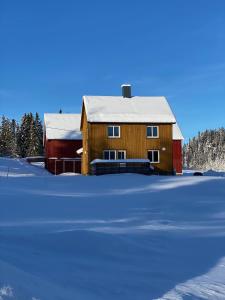 un granero de madera con nieve en el suelo en Fjellstad Gård - 2 minutes from E6 and 5 minutes drive from Steinkjer city en Steinkjer