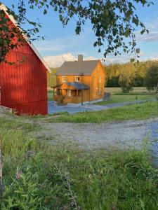 a large barn with a red barn at Fjellstad Gård - 2 minutes from E6 and 5 minutes drive from Steinkjer city in Steinkjer