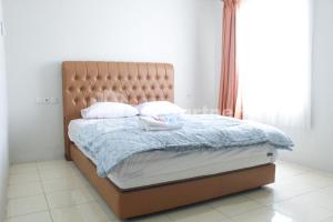 un letto in una camera con una grande finestra di Brahma Hotel Mitra RedDoorz a Giacarta