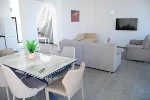 a living room with a table and chairs and a couch at Coral Luxury Villas in Lozenets