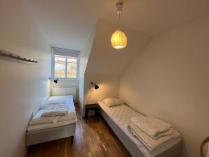 a bedroom with two beds and a pendant light at Sjöängsvägen Funäsdalen in Funäsdalen