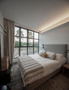 a bedroom with a large bed with a large window at Apartamentos Rosa Velázquez in Merida