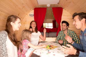 Un groupe de personnes assises autour d'une table jouant aux bougies dans l'établissement Ferienwohnungen & Campingfässer am Kunstteich, à Wettelrode