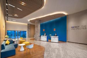 lobby biurowe z niebieską ścianą i żółtymi krzesłami w obiekcie Holiday Inn Express Guiyang Qingyan, an IHG Hotel w mieście Guiyang