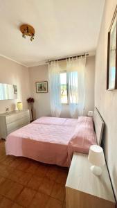 a bedroom with a pink bed and a window at Beatrice Apartment Crocello in Montignoso