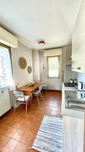 una cucina con tavolo e sedie e una cucina con lavandino di Beatrice Apartment Crocello a Montignoso