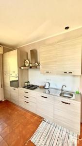 a kitchen with white cabinets and a sink at Beatrice Apartment Crocello in Montignoso