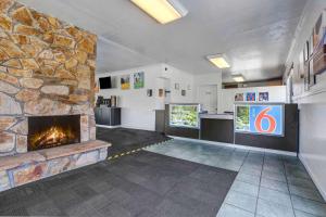 a living room with a stone fireplace in a building at Motel 6-Fort Bragg, CA in Fort Bragg