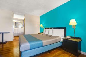 布拉格堡的住宿－布拉格堡第6汽車旅館，一张大床,位于一个蓝色的墙壁内