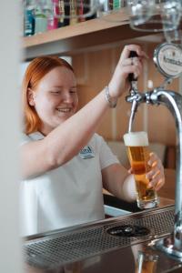 Uma mulher numa cozinha com um copo de cerveja. em Coral beach house & food em Playa de Palma