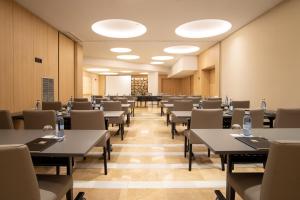 une salle à manger avec des tables, des chaises et des lumières dans l'établissement Hotel Granada Center, à Grenade