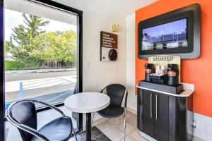 a room with a table and chairs and a tv at Motel 6-Sunnyvale, CA - South in Sunnyvale