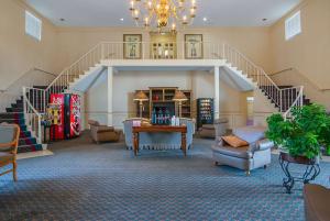 - un salon avec un escalier, des chaises et une table dans l'établissement Motel 6-Ocala, FL - Conference Center, à Ocala Ridge