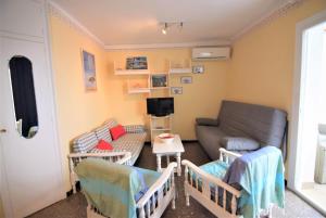 ein Wohnzimmer mit einem Sofa und einem TV in der Unterkunft Apartamento con vista impresionante a la bahía de Roses-189 in Roses