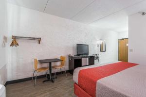 um quarto de hotel com uma cama e uma secretária com uma televisão em Motel 6-Bridgeview, IL em Bridgeview