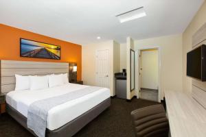a hotel room with a bed and a flat screen tv at Days Inn by Wyndham Monterey-Fisherman's Wharf Aquarium in Monterey